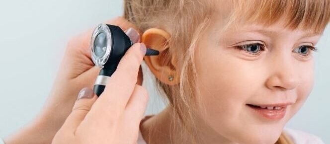 a child's ear being examined by a doctor