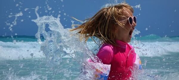 a girl in a pink shirt splashing water