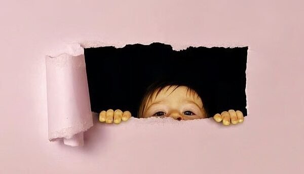 a child looking through a hole in a wall