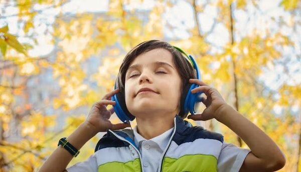 a boy wearing headphones and holding his eyes closed