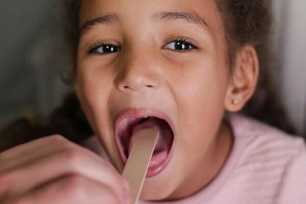 A child with large tonsils undergoing an exam with a Pediatric ENT